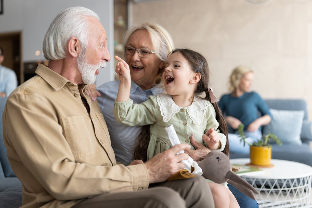 African American senior couple spending quality time with their granddaughter on the sofa